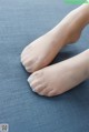 a close up of a person's feet on a blue surface