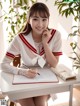 A woman sitting at a desk with a pen and notebook.