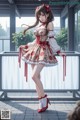 A woman in a red and white dress standing on a balcony.