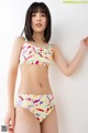 A woman in a bikini top and high waisted bottoms posing for a picture.