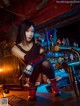 A woman sitting on top of a bar next to a beer tap.