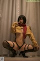 A woman in a yellow jacket and black stockings posing for a picture.