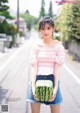 A woman holding a watermelon in her hands.