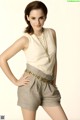 A woman in a white top and gray shorts posing for a picture.